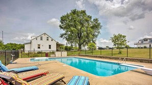 A swimming pool with lounge chairs and a house in the background. - Charming Berger Apt on 42-acre Farm w/ Pool Access (Berger)