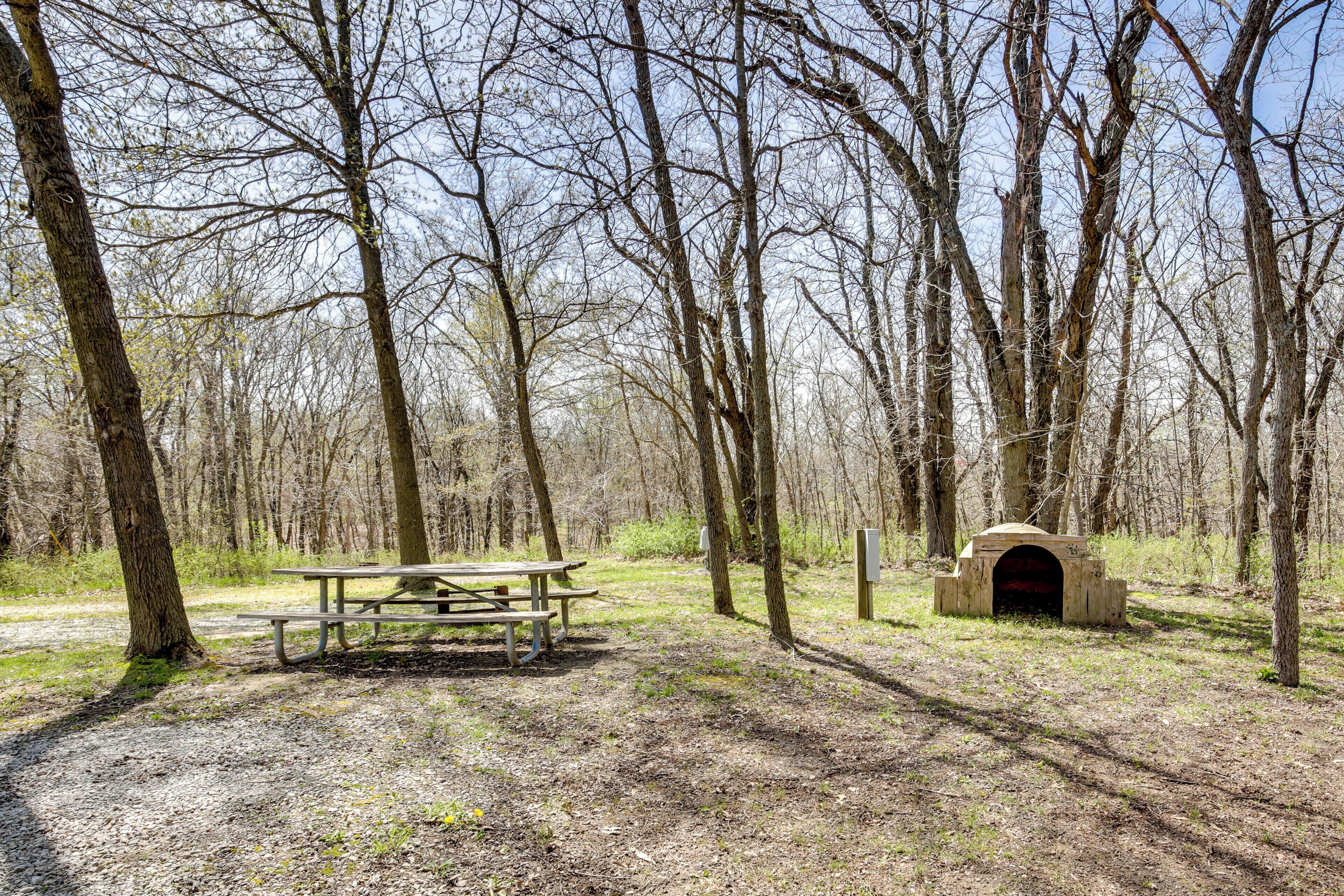 A picnic area with a table and benches surrounded by trees.
