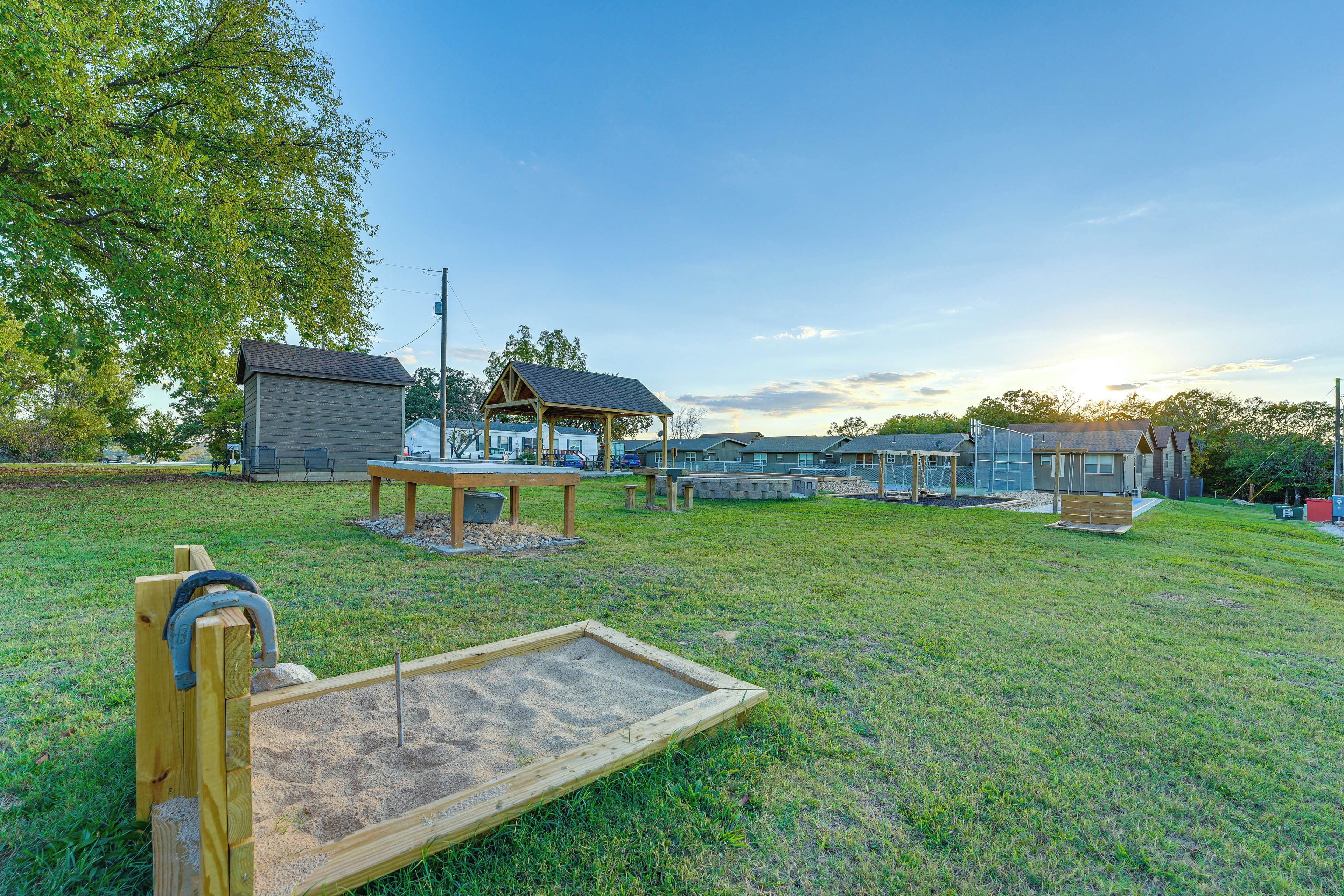 A playground with a sandbox, picnic table, and wooden structures.