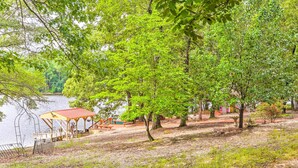 A lakeside park with picnic tables, a gazebo, and a walking path. - Cheery Swansea Home on Calmont Pond w/ Dock! (Swansea)