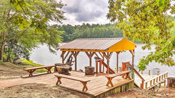 A wooden dock with benches and a covered seating area overlooking a lake. - Cheery Swansea Home on Calmont Pond w/ Dock! (Swansea)