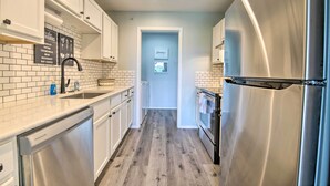 A kitchen with white cabinets, a stainless steel refrigerator, and a dishwasher. - Cheerful Condo: Patio, 2 Mi to Branson Strip! (Branson)