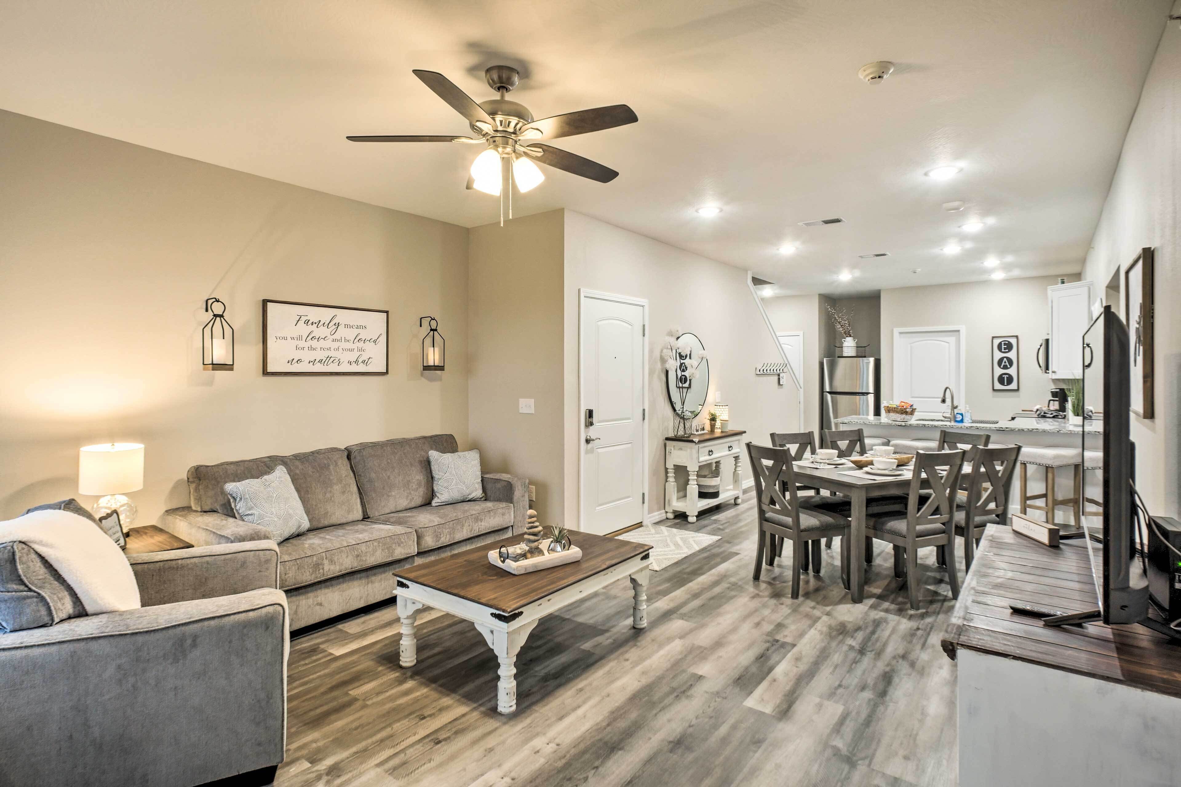 A spacious living room with a gray sofa, a wooden coffee table, and a ceiling fan.
