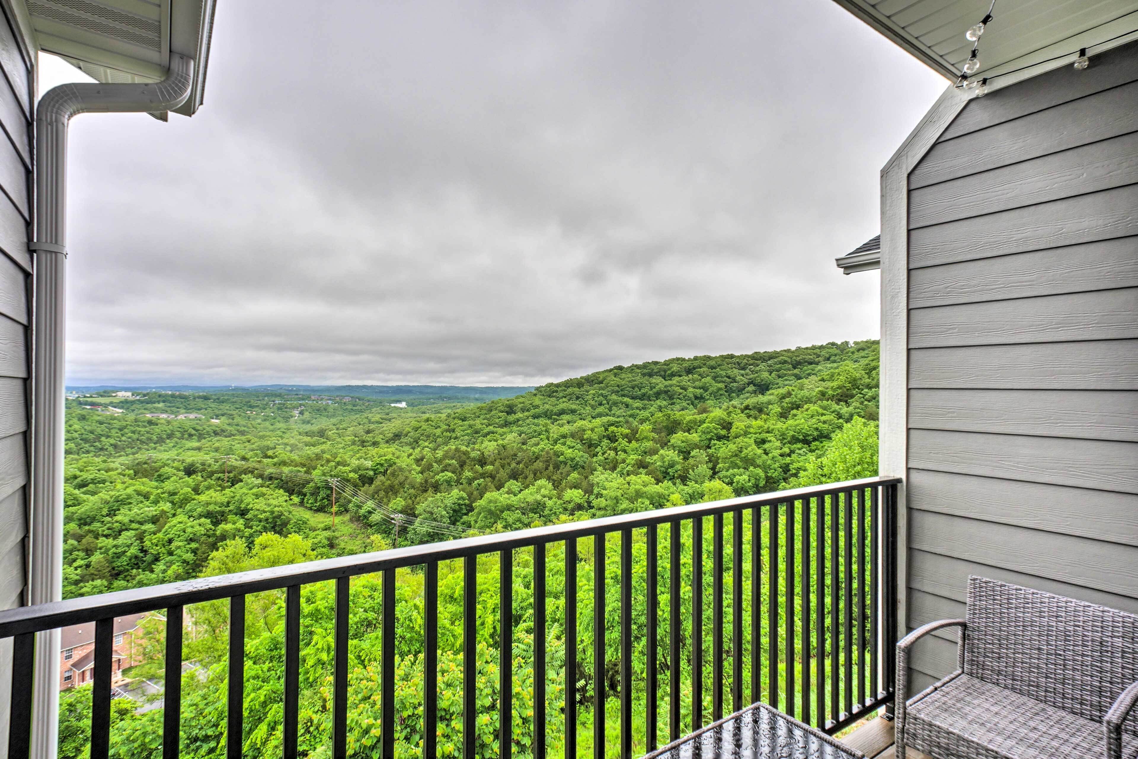 A balcony with a view of a forested landscape.