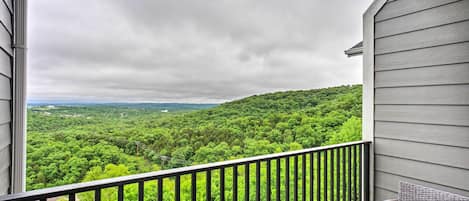 A balcony with a view of a forested landscape.