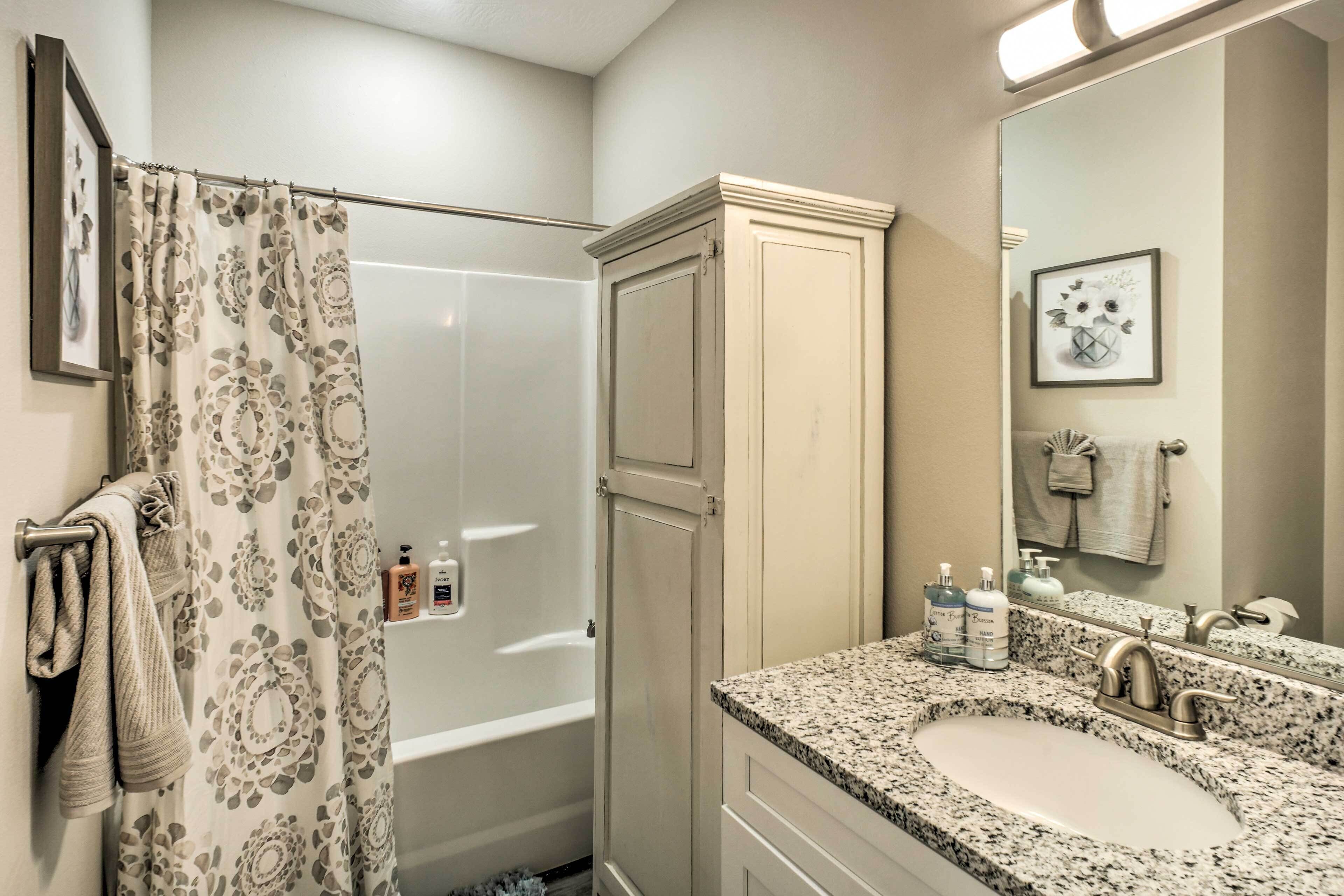 Une salle de bain avec une douche, un lavabo et un miroir.