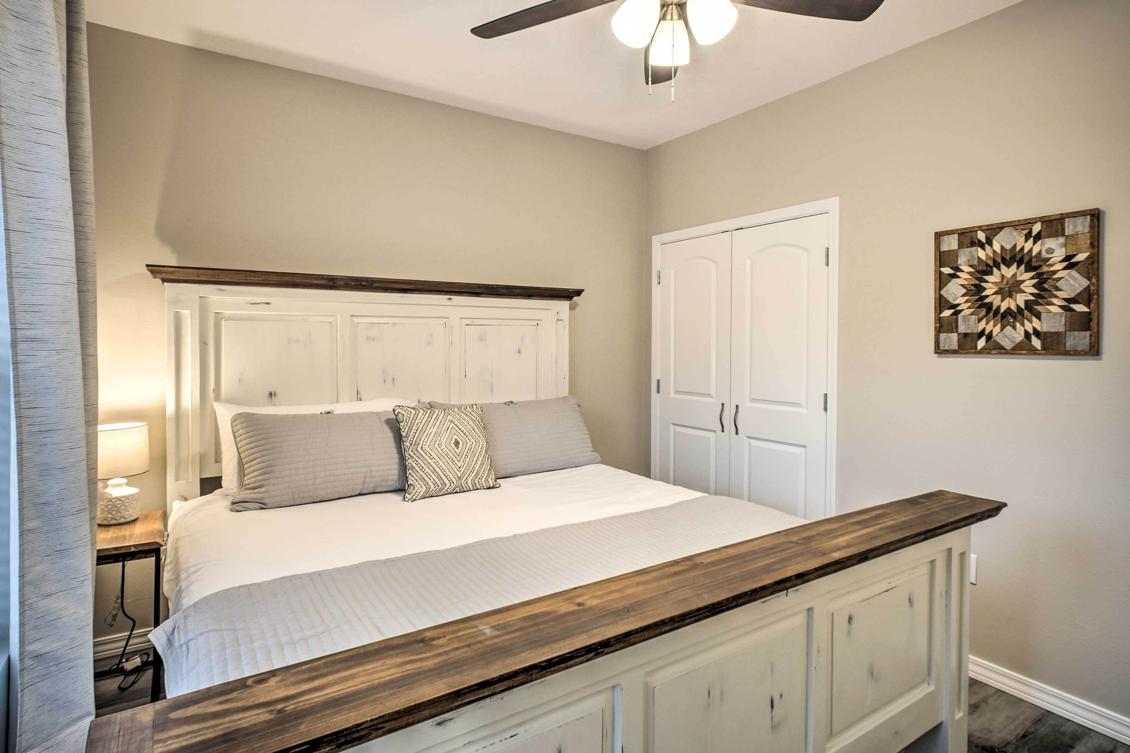 A bedroom with a bed, nightstand, dresser, and a ceiling fan.