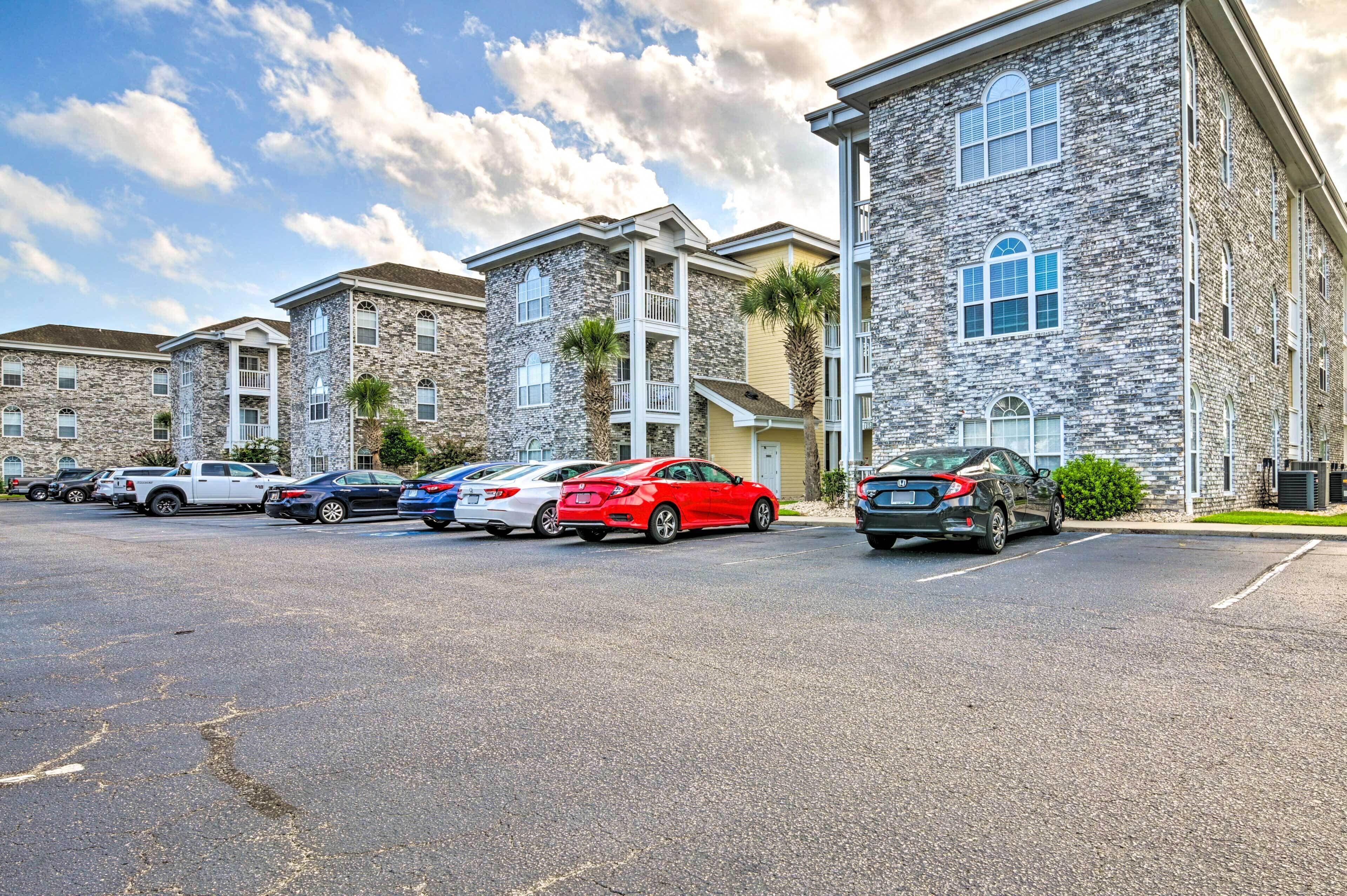 A row of stone buildings with parking spaces in front.