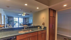 Una cocina moderna con encimera de granito, pileta de acero inoxidable y armarios de madera.
