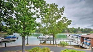 A lakeside view with boats docked, a wooden bridge, and a covered boat storage area. - Condo on Lake Keowee w/ Resort Amenities & Pool! (Salem)