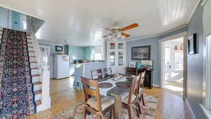 A dining area with a wooden table and chairs, a ceiling fan, and a staircase with a patterned carpet. - Cozy Augusta Home w/ Porch: Walk to Katy Trail! (Augusta)
