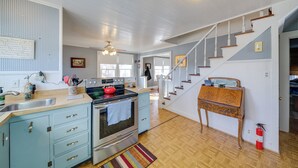 A spacious kitchen with a wooden staircase, a built-in oven, and a small dining table. - Cozy Augusta Home w/ Porch: Walk to Katy Trail! (Augusta)