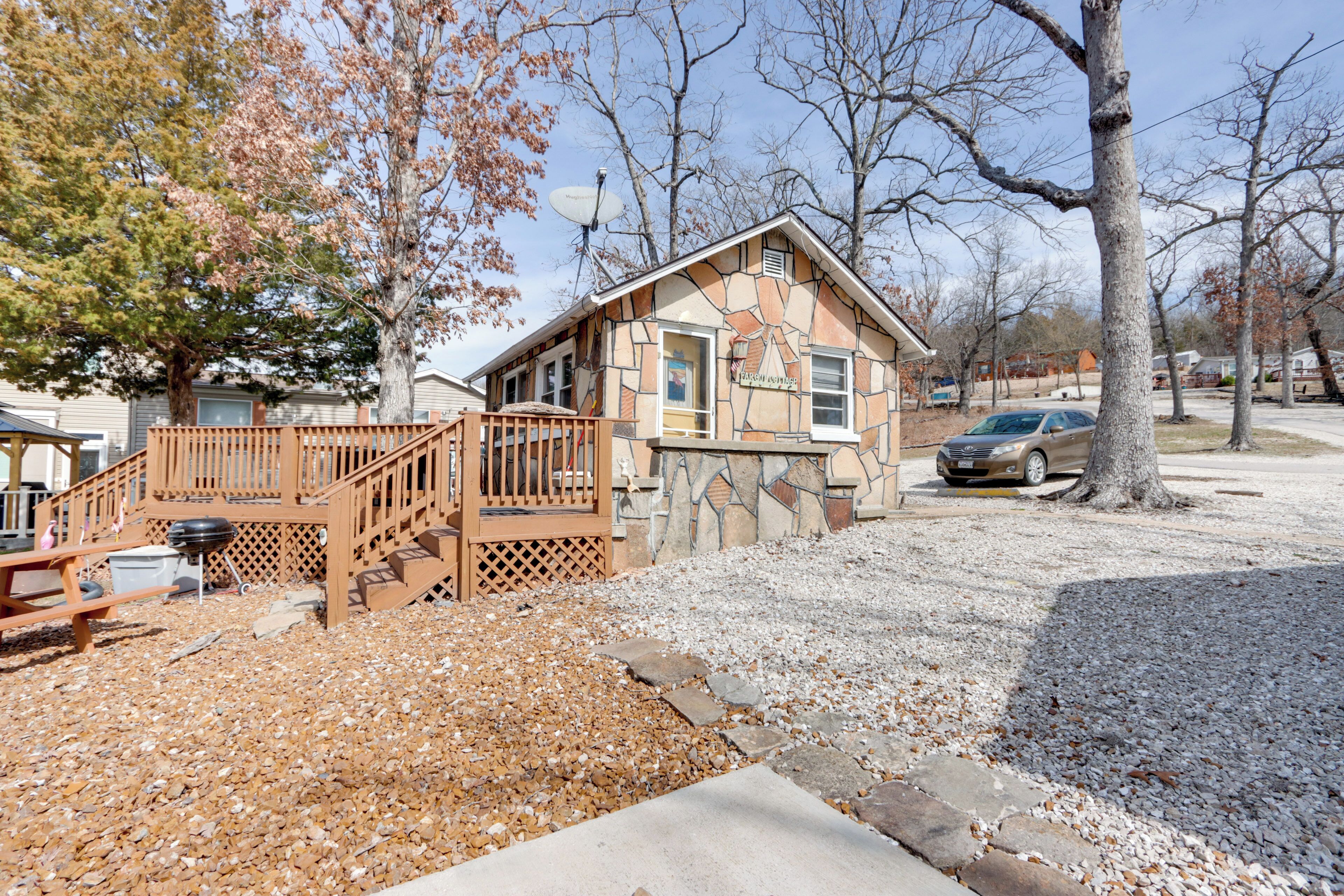 A house with a stone facade, wooden deck, and a satellite dish.