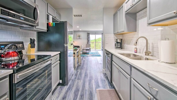 A modern kitchen with stainless steel appliances, a microwave, and a red kettle.