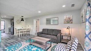 A modern living room with a grey sofa, a coffee table, and patterned rugs.