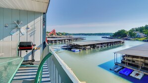 A balcony with a view of a marina, boats docked, and a clear sky. - Pool + Boat Slip Available: Osage Beach Condo! (Osage Beach)