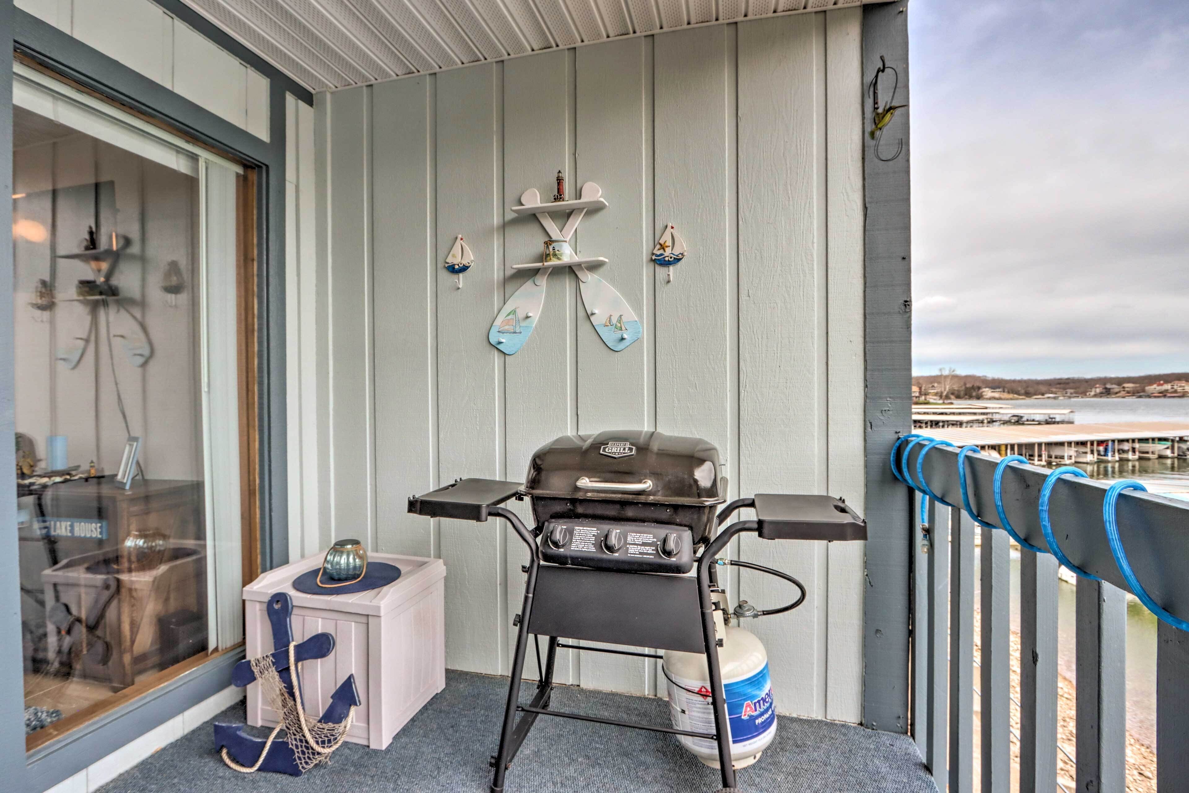 Een balkon met een barbecue, een tafeltje en een decoratieve anker.