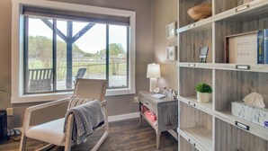 A room with a large window, a rocking chair, a wooden cabinet with shelves, and a framed inspirational quote. - Waterfront Home Near Mark Twain National Forest (Poplar Bluff)