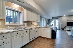A modern kitchen with white cabinetry, a granite countertop, and a large window. - Waterfront Home Near Mark Twain National Forest (Poplar Bluff)