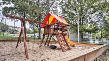 A playground with a swing set, a slide, and a climbing structure.