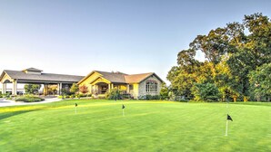 Um campo de golfe com um clube e um gramado bem cuidado.