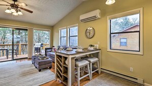 A spacious kitchen with a dining area, large windows, and a view of a cabin. - Cozy Table Rock Lake Vacation Rental w/ Deck (Golden)