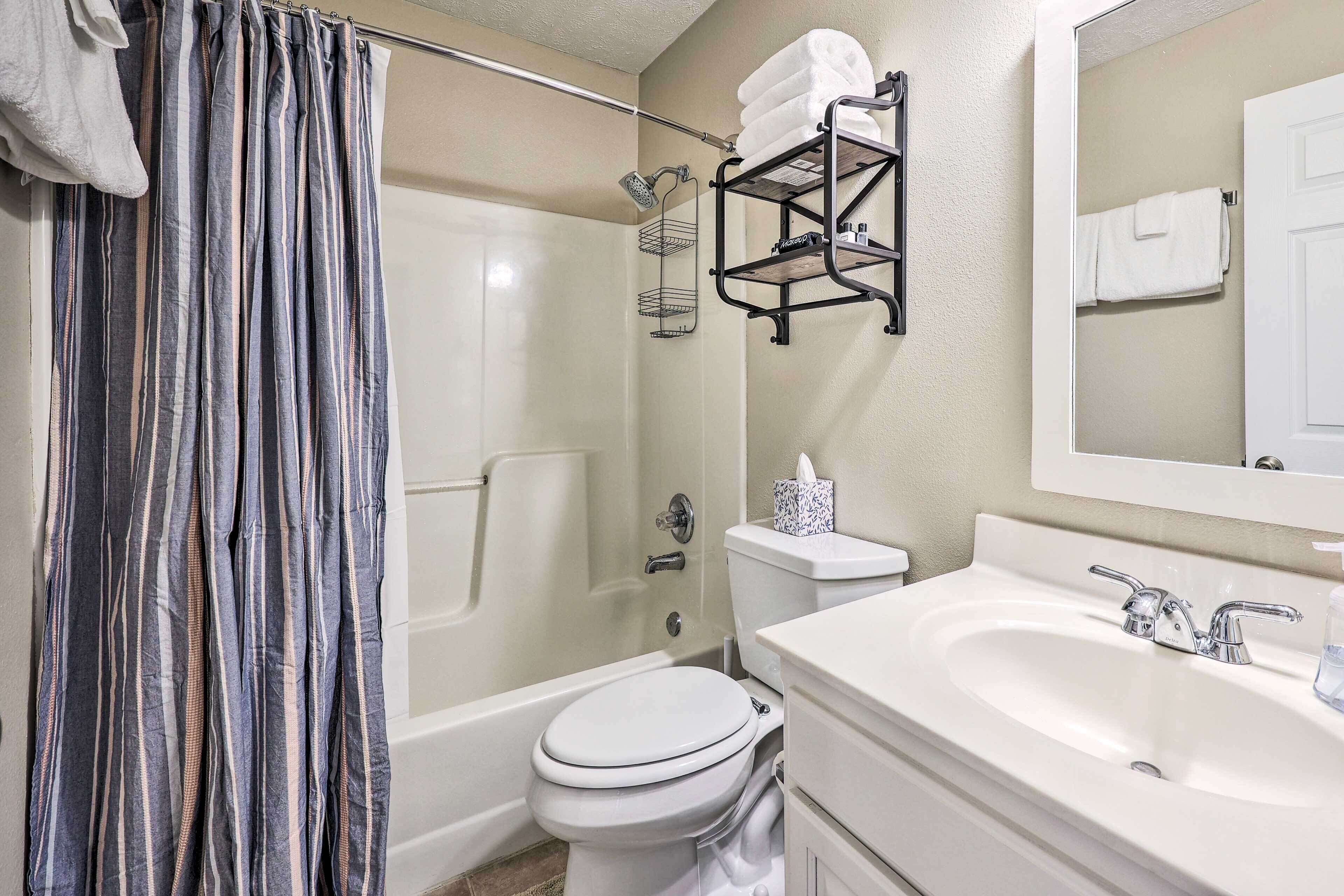 A bathroom with a shower, toilet, and sink.