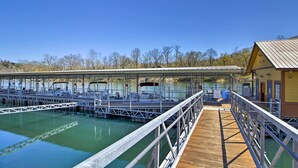 Un port de plaisance où les bateaux sont amarrés, doté d’une passerelle couverte et d’un petit bâtiment.