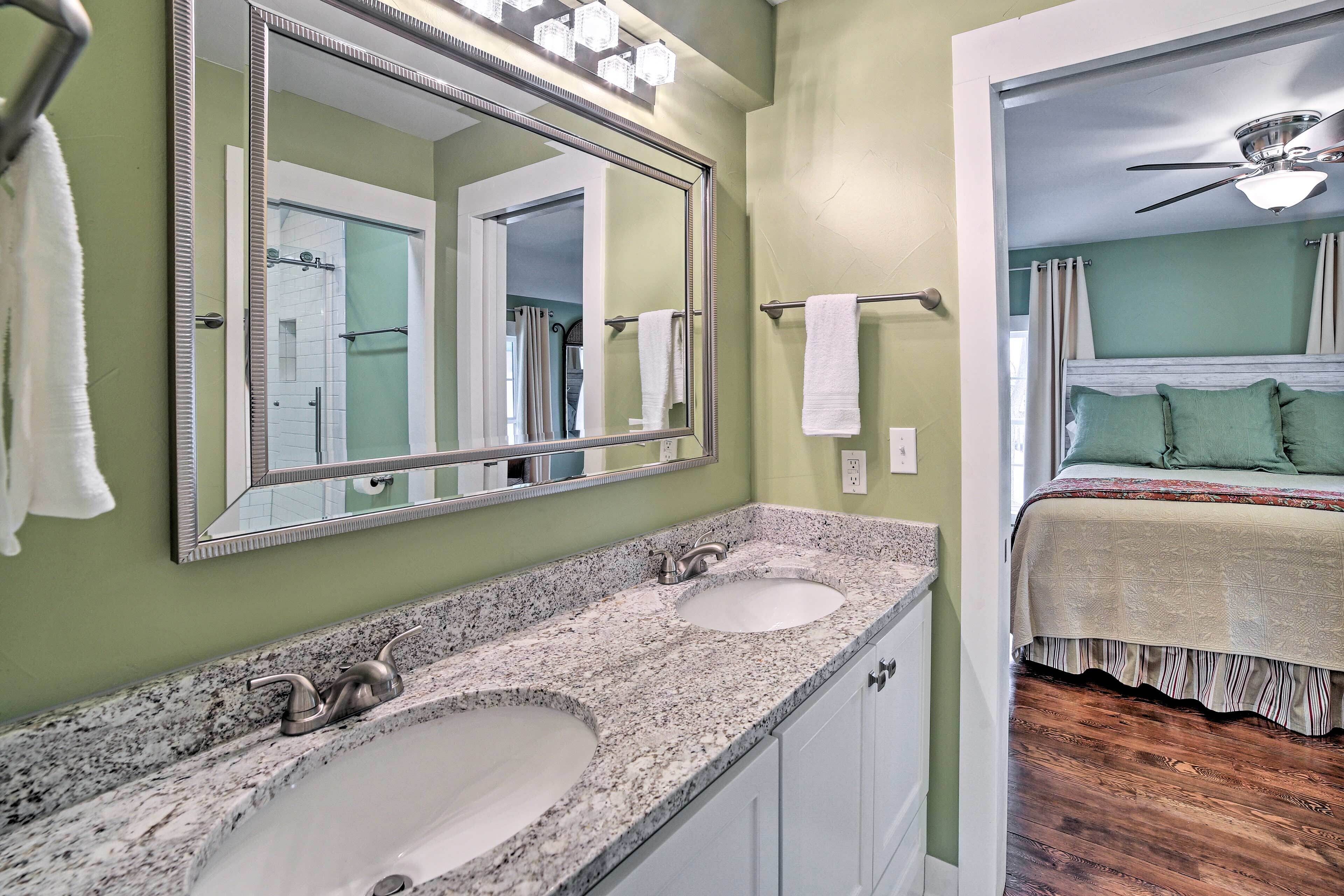 A bathroom with two sinks, a large mirror, and a ceiling fan.