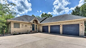 A two-story house with a garage, a front porch, and a driveway. - Lakefront Family Retreat in Osage Beach! (Osage Beach)