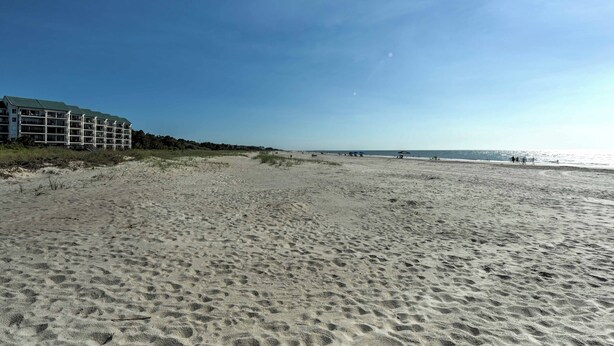 Ein Strand mit einem Gebäude links.