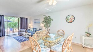 A spacious living area with a dining table, chairs, and a ceiling fan. - Patio & Walk to Beach: Hilton Head Island Townhome (Hilton Head Island)