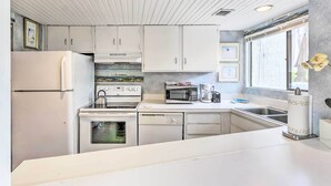 A modern kitchen with white cabinetry, a refrigerator, stove, microwave, and dishwasher. - Patio & Walk to Beach: Hilton Head Island Townhome (Hilton Head Island)