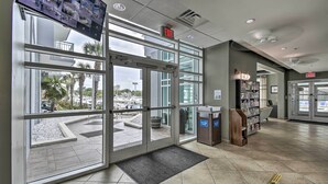 A hotel entrance with glass doors, a reception desk, and a view of the parking area. - 2 Mi to Ocean: Waterfront Resort Condo in Nmb! (North Myrtle Beach)