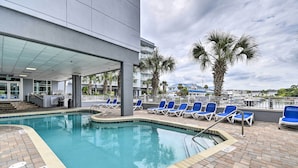 A pool area with lounge chairs, a lifeguard station, and a view of the ocean. - 2 Mi to Ocean: Waterfront Resort Condo in Nmb! (North Myrtle Beach)