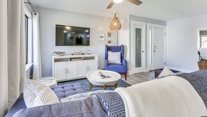 A modern living room with a ceiling fan, a blue armchair, a white sofa, and a coffee table. - Walk to Coligny Beach: Tropical Hilton Head Condo (Hilton Head Island)