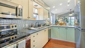 A modern kitchen with stainless steel appliances, a tiled backsplash, and light-colored cabinetry. - Holiday Hills Resort Condo: 3 Mi to Branson Strip! (Branson)