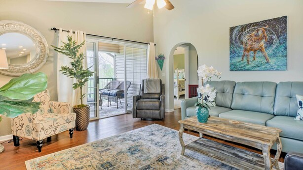 A spacious living room with a ceiling fan, a large mirror, a sofa, a coffee table, and a painting of a dog. - Holiday Hills Resort Condo: 3 Mi to Branson Strip! (Branson)