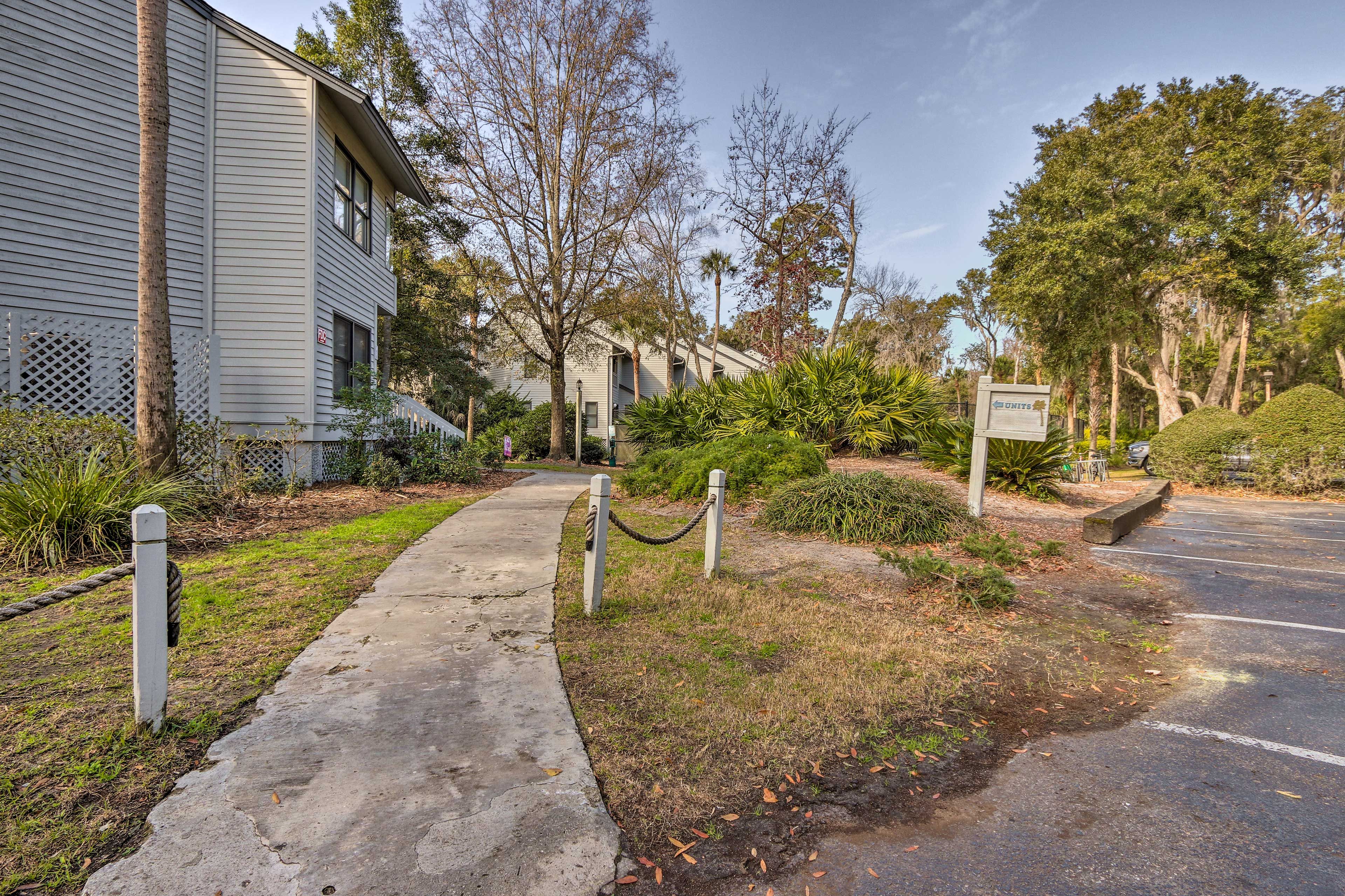 A gated residential area with a pathway leading to a parking lot.