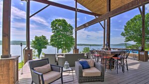 A covered deck with outdoor furniture, a barbecue area, and a view of a lake. - Inviting Home w/ Pool & Hot Tub on Table Rock Lake (Lampe)