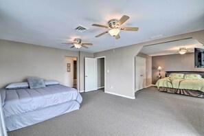 A bedroom with two beds, a ceiling fan, and a carpeted floor. - Inviting Home w/ Pool & Hot Tub on Table Rock Lake (Lampe)