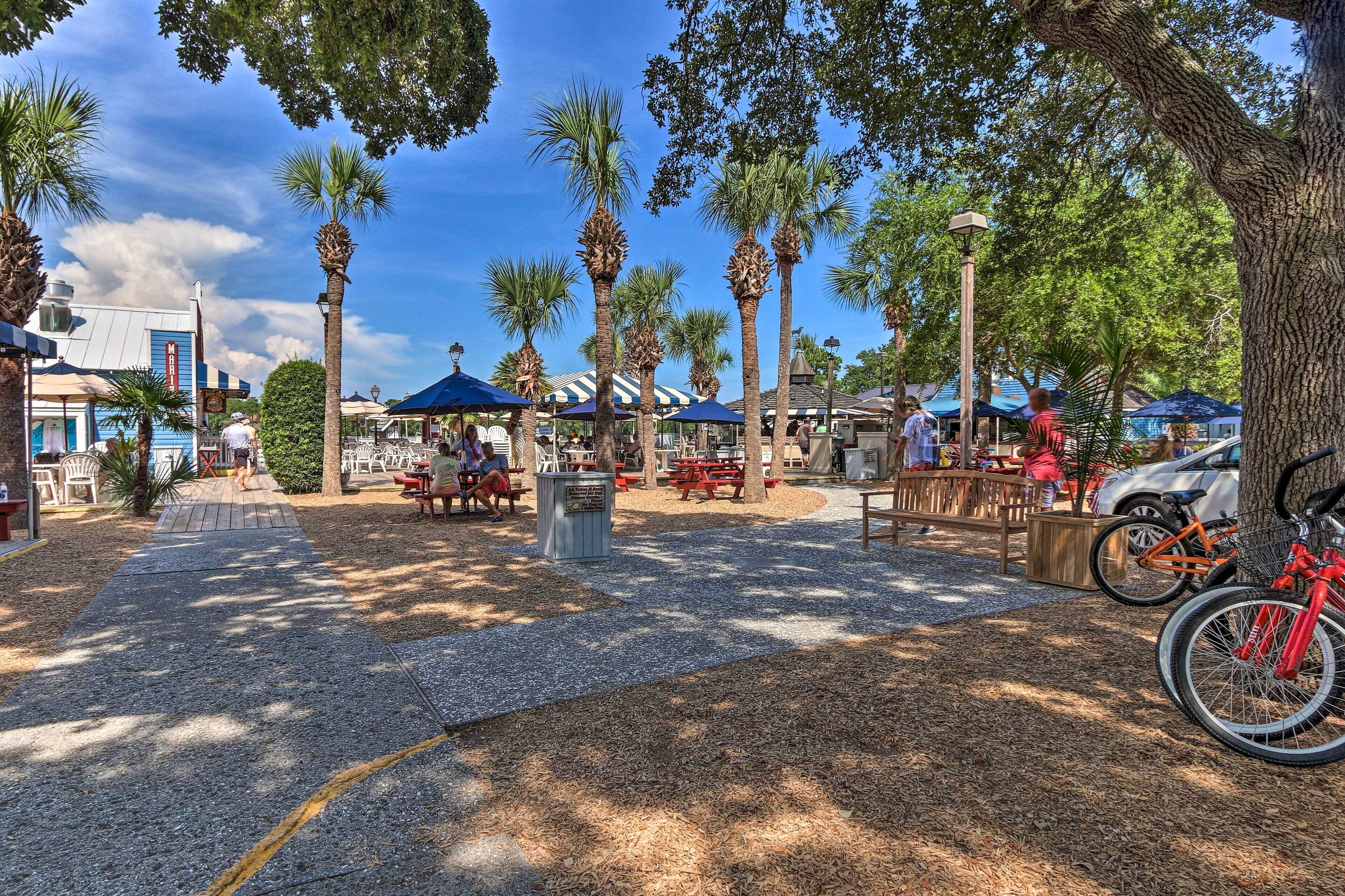 Un parc avec des palmiers, des tables de pique-nique et des vélos.