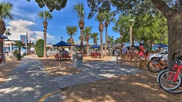 A park with palm trees, picnic tables, and bicycles.