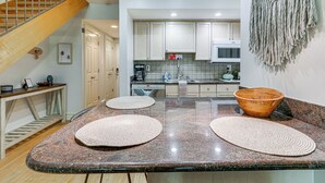A kitchen with granite countertops, wooden stools, and a wooden bowl. - Pool Access: Idyllic Sea Pines Gem, Walk to Beach (Hilton Head Island)