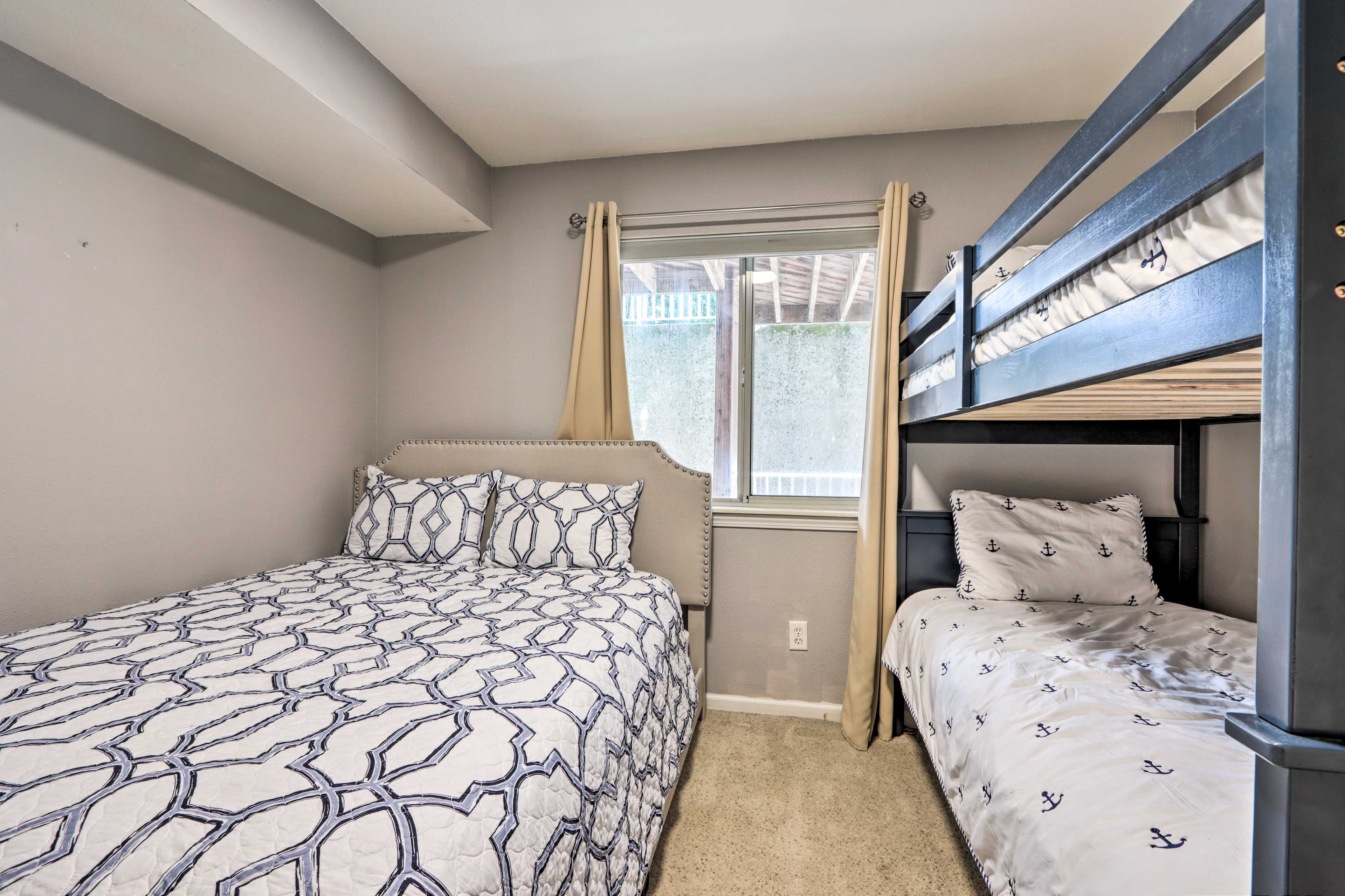 A bedroom with a single bed, a bunk bed, a window with curtains, and a carpeted floor.