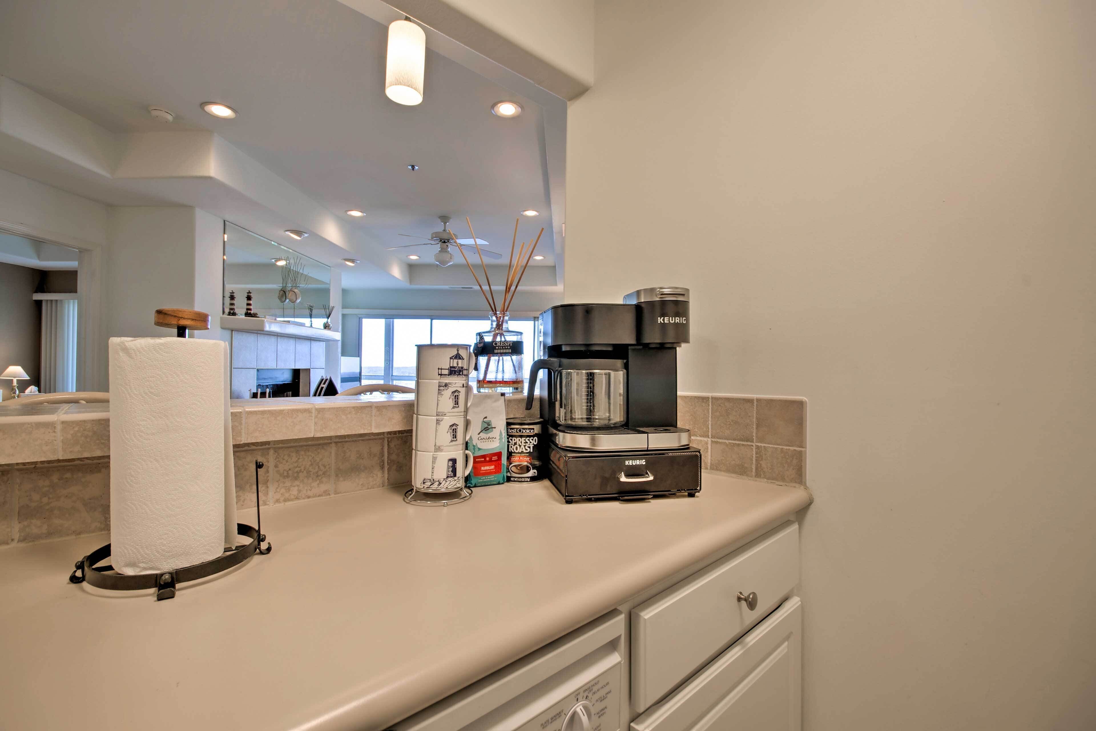 A modern kitchen with a coffee maker, paper towel holder, and a coffee pod dispenser.