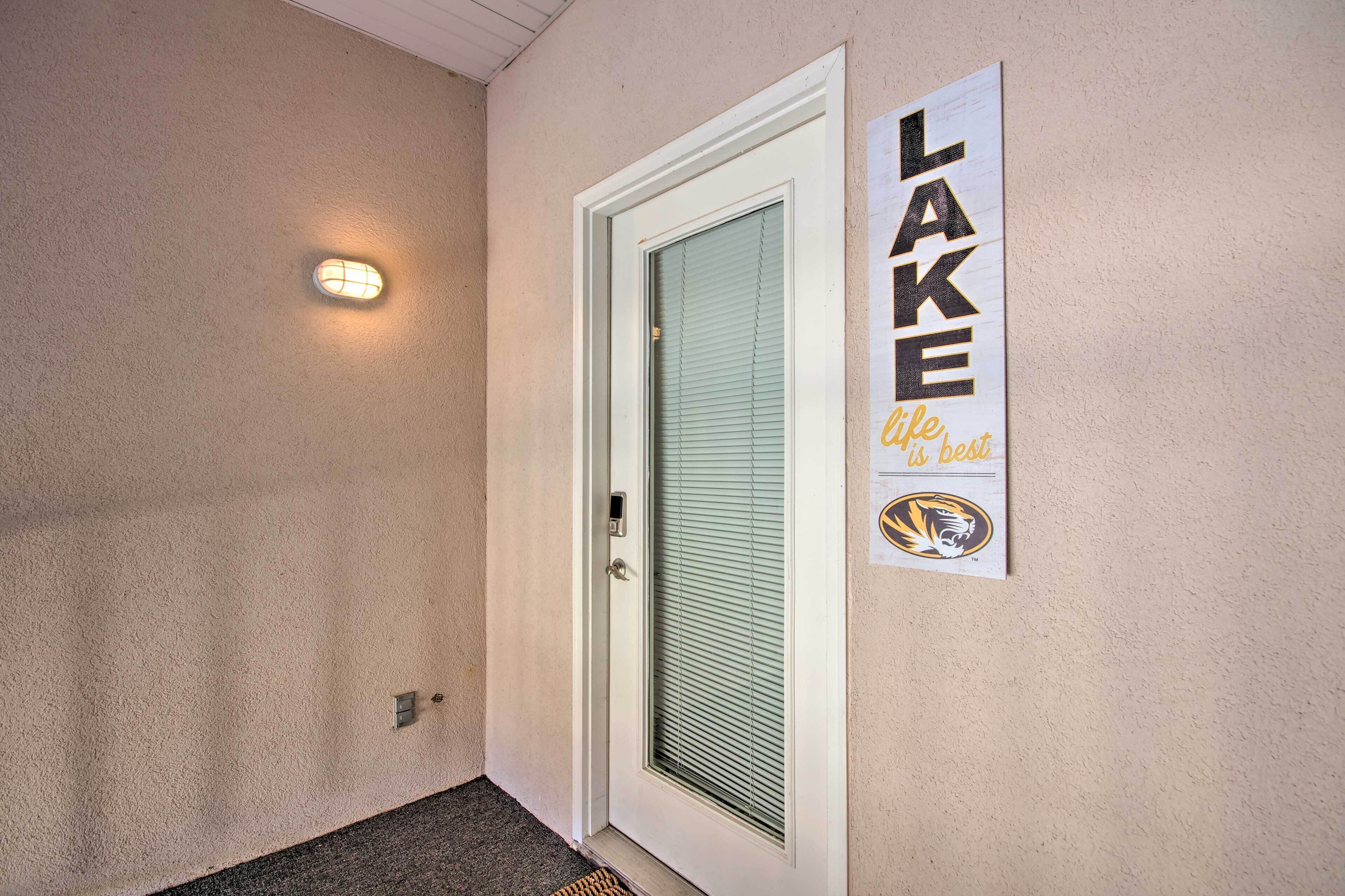 Eine Tür mit Fenster und einem Schild, auf dem steht: „LAKE life is best“ mit einem Tiger-Logo.