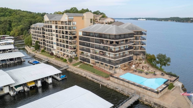 Un hôtel situé au bord de l’eau, doté de nombreux balcons, d’une piscine et de bateaux amarrés.
