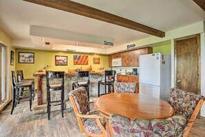 A kitchen with a wooden table and chairs, a refrigerator, and a microwave. - Kimberling City Home w/ Table Rock Lake Views! (Kimberling City)