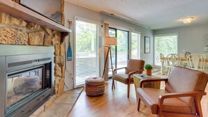 A cozy living room with a stone fireplace, comfortable seating, and a dining area. - Oasis at Spring Valley Cove, Quiet, Private Dock (Osage Beach)